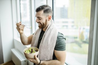 Mann isst nach dem Sport einen Salat