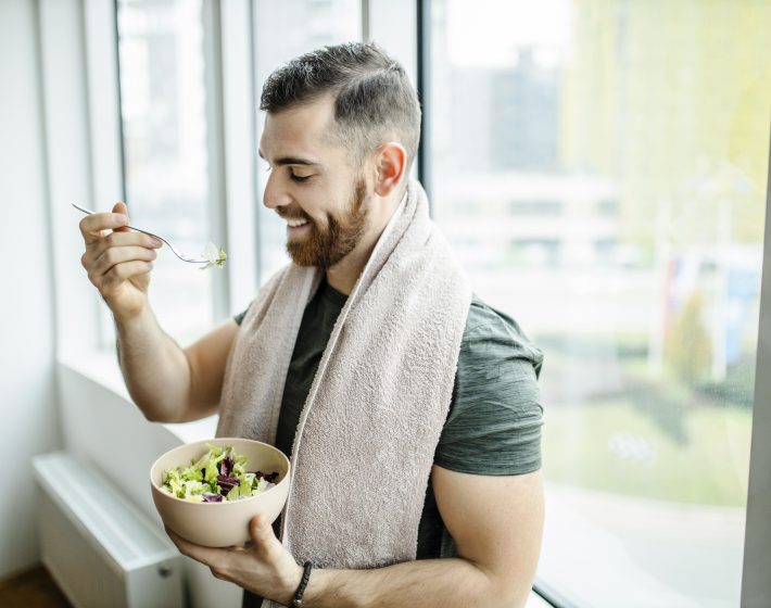 Mann isst nach dem Sport einen Salat